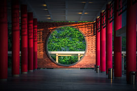 Framed Stillness – Between Red Columns by The Hazel Perspective