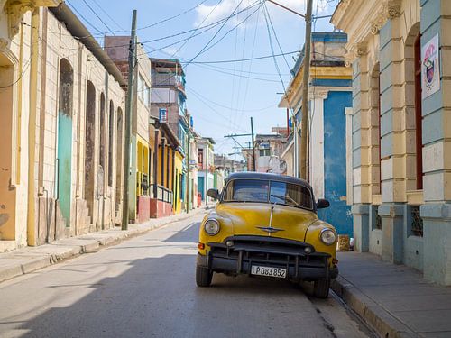 Yellow oldtimer in the States of Santiago de Cuba by Teun Janssen