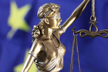Symbolisch beeld: Justitia voor een Europese vlag