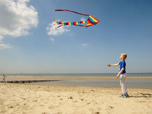Jongen met vlieger op het strand