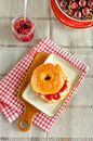 Ein selbst gebackener Bagel mit Frischkäse und Kirschmarmelade liegt auf einem Teller von Edith Albuschat Miniaturansicht