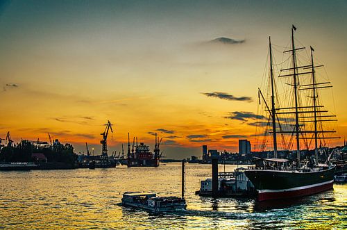 Haven van Hamburg met zeilboot bij zonsondergang
