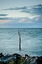 Visnetten met stokken in het IJsselmeer tijdens een kleurrijke zonsondergang van Fotografiecor .nl thumbnail