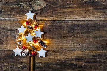 Kerstboomdecoratie met rode kerstballen, witte stervormen en dennenappels van Alex Winter