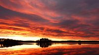 Zonsopgang met een vurige wolkenlucht weerspiegeld in het Ösjön meer. van Aagje de Jong thumbnail