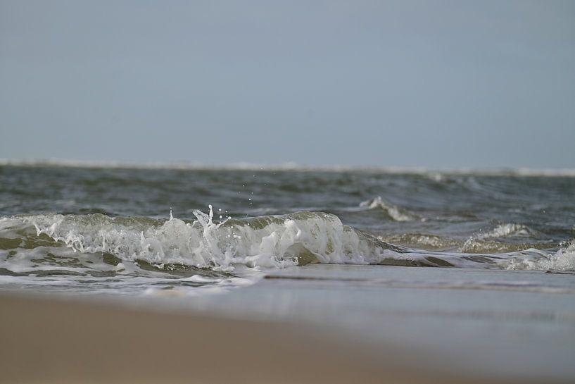 Kleine Welle brandet an den Strand von Marie Janssen