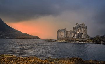 Stimmungsvolles Foto von Eilean Donan Castle während eines farbenprächtigen Sonnenuntergangs. Dramatisches Licht, raues Wasser und schottische Natur als zeitloser Wandschmuck.
