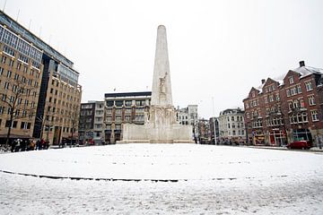 Snowy Damsquare in Amsterdam the Netherlands with the National Monument in winter van Eye on You