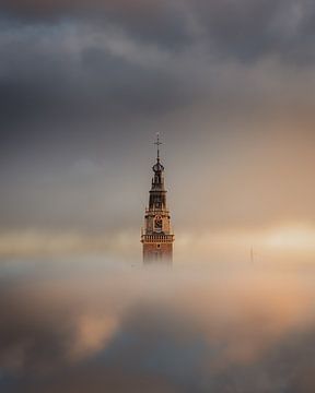 Waagtoren die tussen de wolken oprijst van Larissa van Hooren