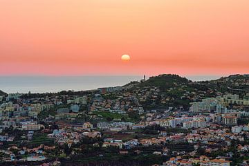 De avond valt met een mooi oranje kleurende lucht boven Funchal Madeira van Robbie Nijman