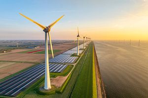 Windturbinen und Sonnenkollektoren an einem Seeufer