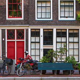 Grachtenpand in Amsterdam met rode deuren en motorrijder in rood van Suzan Baars