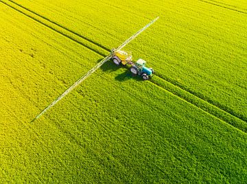 Tractor with an agriculutural crops sprayer from above by Sjoerd van der Wal