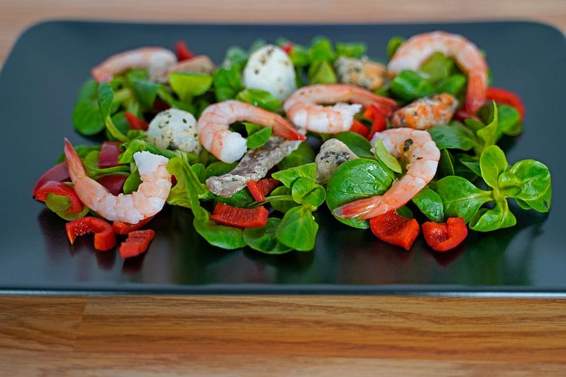 Lamb's lettuce with peppers and seafood served on a black serving platter by Babetts Bildergalerie