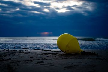 Boei op het strand met zonsondergang van Fotografie Schnabel
