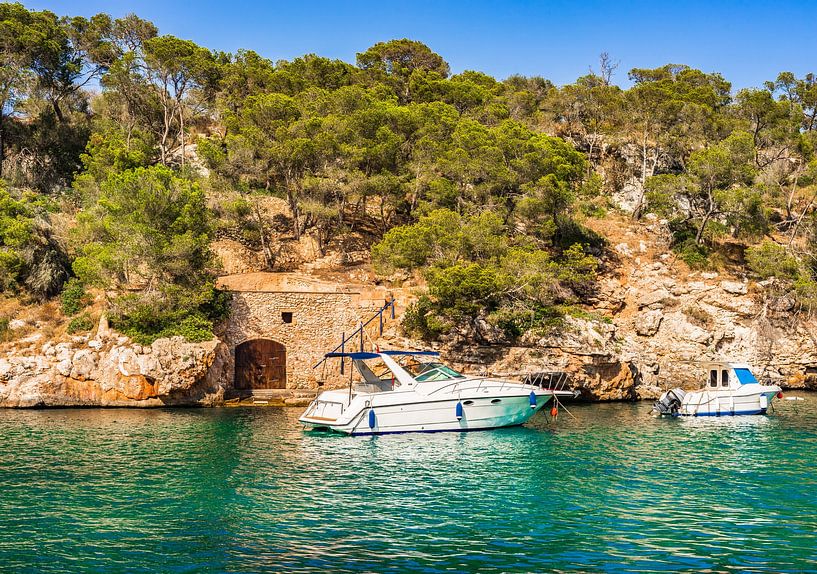 Idyllic bay with motorboat yacht at the coast on Mallorca by Alex Winter