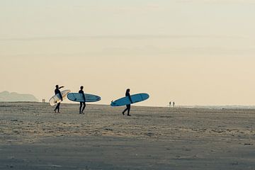 Surfers lopen met hun board richting de zee van Surfen - Alex Hamstra Photography