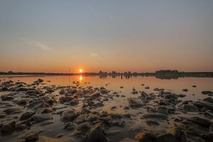 Stenen bij rivier De Lek tijdens zonsondergang van Moetwil en van Dijk - Fotografie