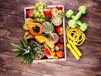 Gezond leefstijlconcept met sportuitrusting en flessen fruitsappen