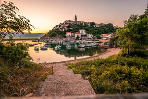ein Mediteranes dorf am meer mit hafen auf einem Felsen gebaut