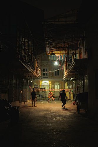 Straatbeeld bij nacht: voetbal op de binnenplaats