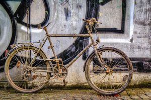 Altes schmutzige Fahrrad an Mauer mit Graffiti von Dieter Walther
