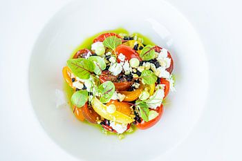 Colourful salad presented on white plate