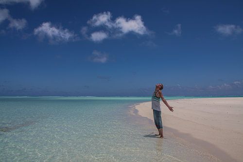 Ein Mann steht im Paradies der Lagune von Aitutaki