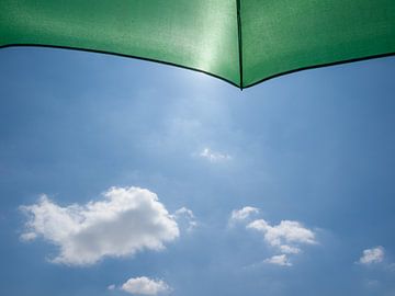 Green fishing umbrella in the sun by Ramon Bovenlander