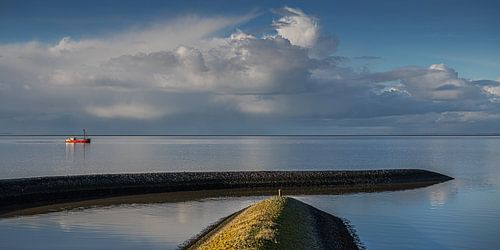 La mer des Wadden avec quelques bateaux de pêche par une journée sans vent.