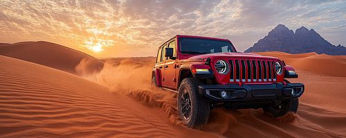Roter Jeep Wrangler bei Sonnenuntergang in den Dünen