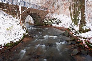 Een klein riviertje met een brug gefotografeerd tijdens de winter in de Belgische Ardennen.