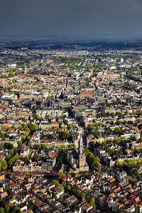 Luchtopname van de binnenstad van Amsterdam met de Westerkerk in de voorgrond en een zwarte regenbui van Marco van Middelkoop