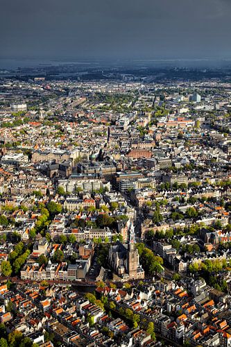 Luchtopname van de binnenstad van Amsterdam met de Westerkerk in de voorgrond en een zwarte regenbui