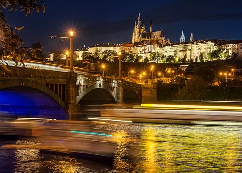 Prague castle in the evening with light stripes on the water