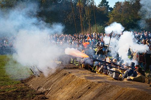 Musketeers in trench fire salvo with gunpowder fumes and fire on historic battlefield