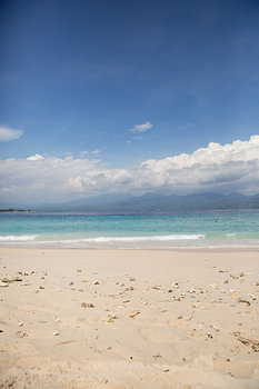 Beach and sea with clouds and an island