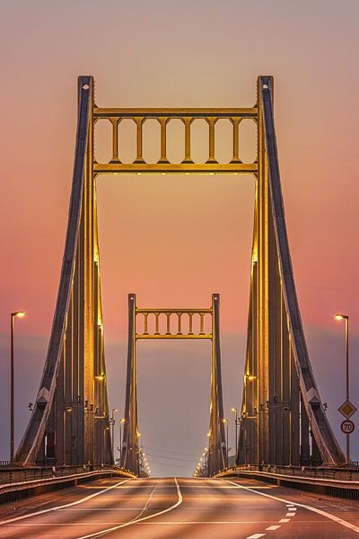 Die Krefeld Uerdinger Brücke, im goldenen Licht, präsentiert sich als ein majestätisches Bauwerk, das die Schönheit der Ingenieurskunst mit der Magie des Sonnenaufgangs vereint. von LICHTERKISTE
