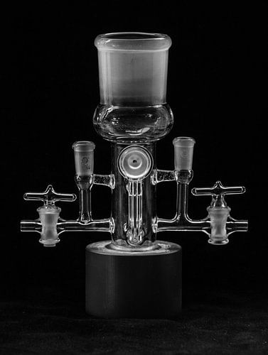 Schwarz-Weiß-Foto von einem Glas-Labor-Objekt gegen einen dunklen Hintergrund in subtilen Beleuchtun