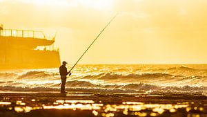 Pêcheur sur la plage au coucher du soleil sur VIDEOMUNDUM