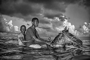 Jungen kühlen ihre Pferde im Meer ab von Frans Lemmens