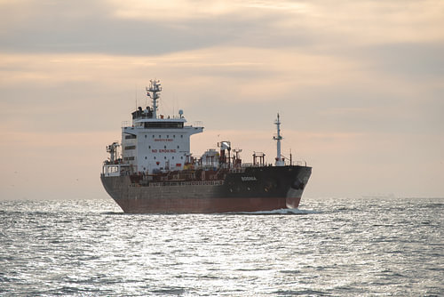 Aan de horizon verschijnt een zeeschip van scheepskijkerhavenfotografie