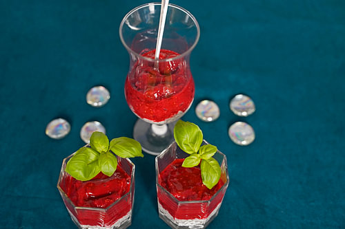 Dessert met frambozenpuree geserveerd in een glas