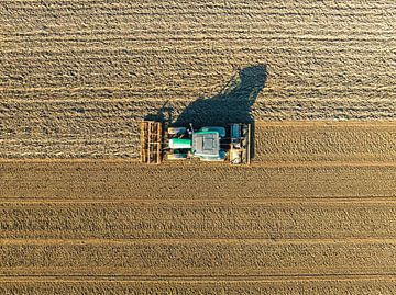 Tractor die de grond bewerkt in de lente van bovenaf gezien van Sjoerd van der Wal