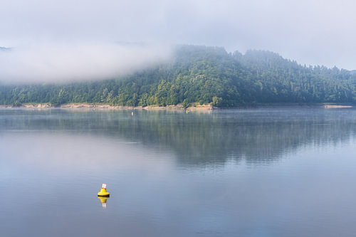 Une bouée dans la brume matinale sur le lac d'Eder