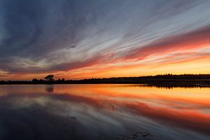 Farbenfroher Sonnenuntergang an einem spiegelglatten See