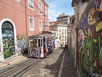 Old tram and graffiti in an alleyway in Lisbon