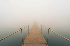 Steg ins Nichts im dichten Nebel – Minimalistisches Holzsteg-Wandbild