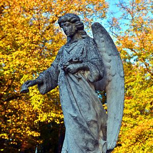 Zauberhafter Engel vor buntem Herbstlaub 
