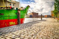 Groen en rood schip aan de kade
